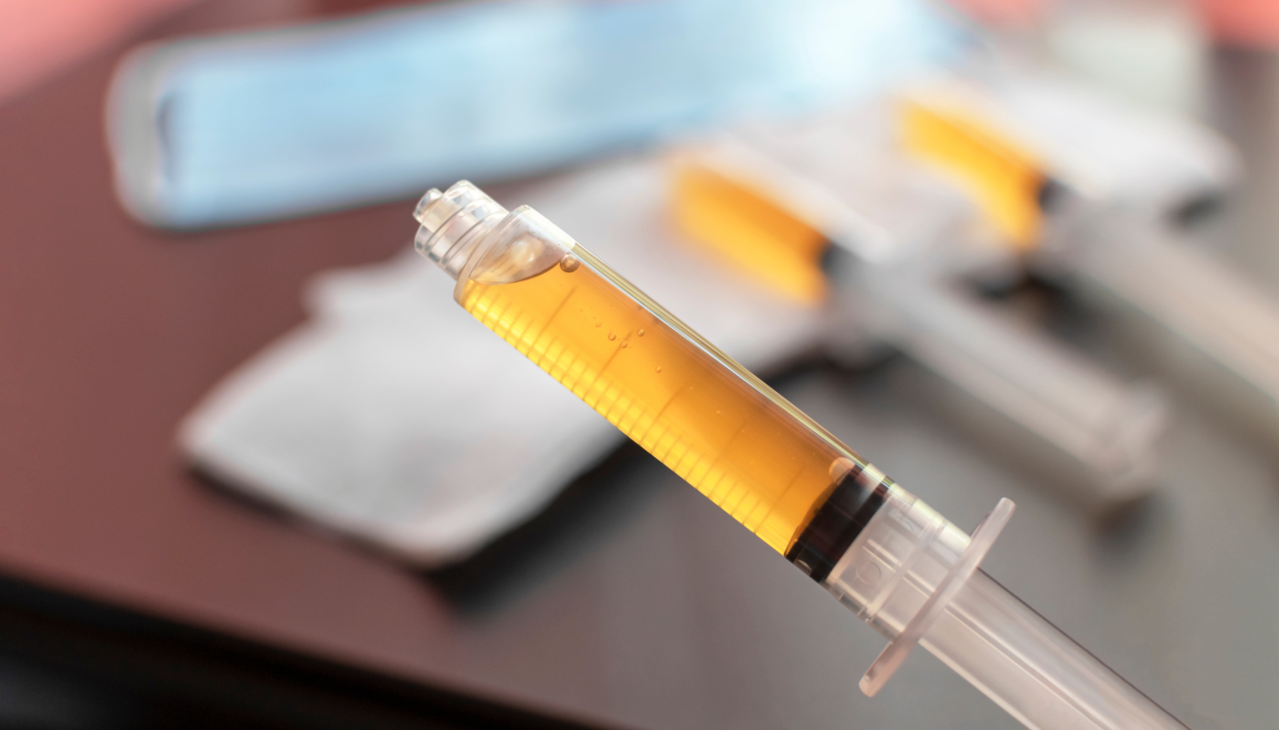 Blood plasma in a syringe on a blurred background. Blood plasma as a solution for the treatment of coronavirus.